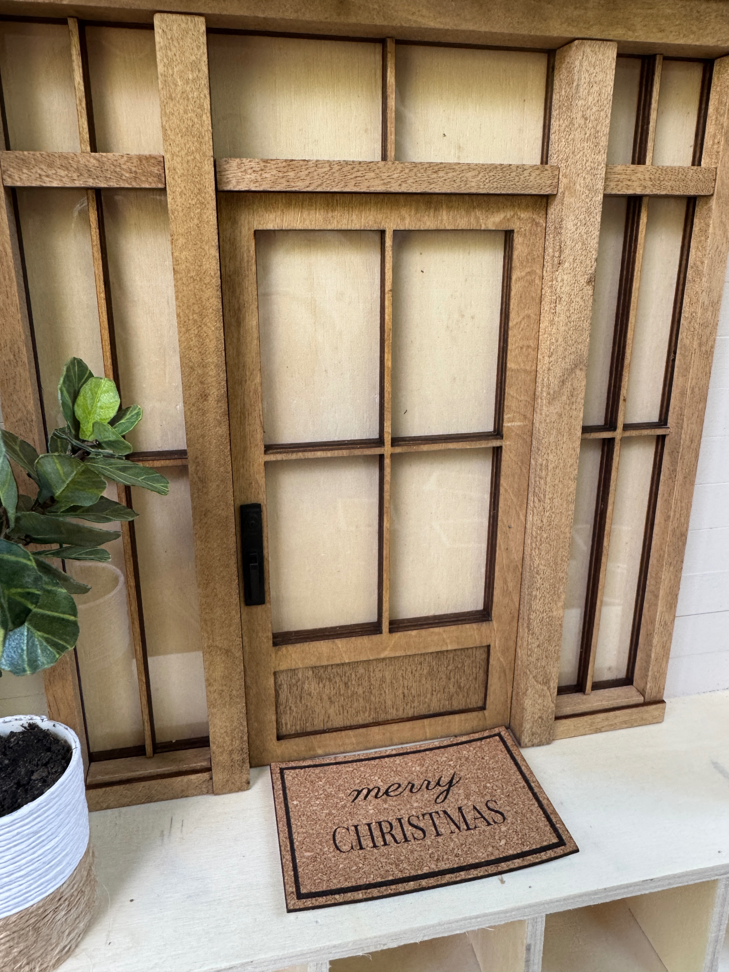 Handcrafted miniature front door with a merry Christmas doormat